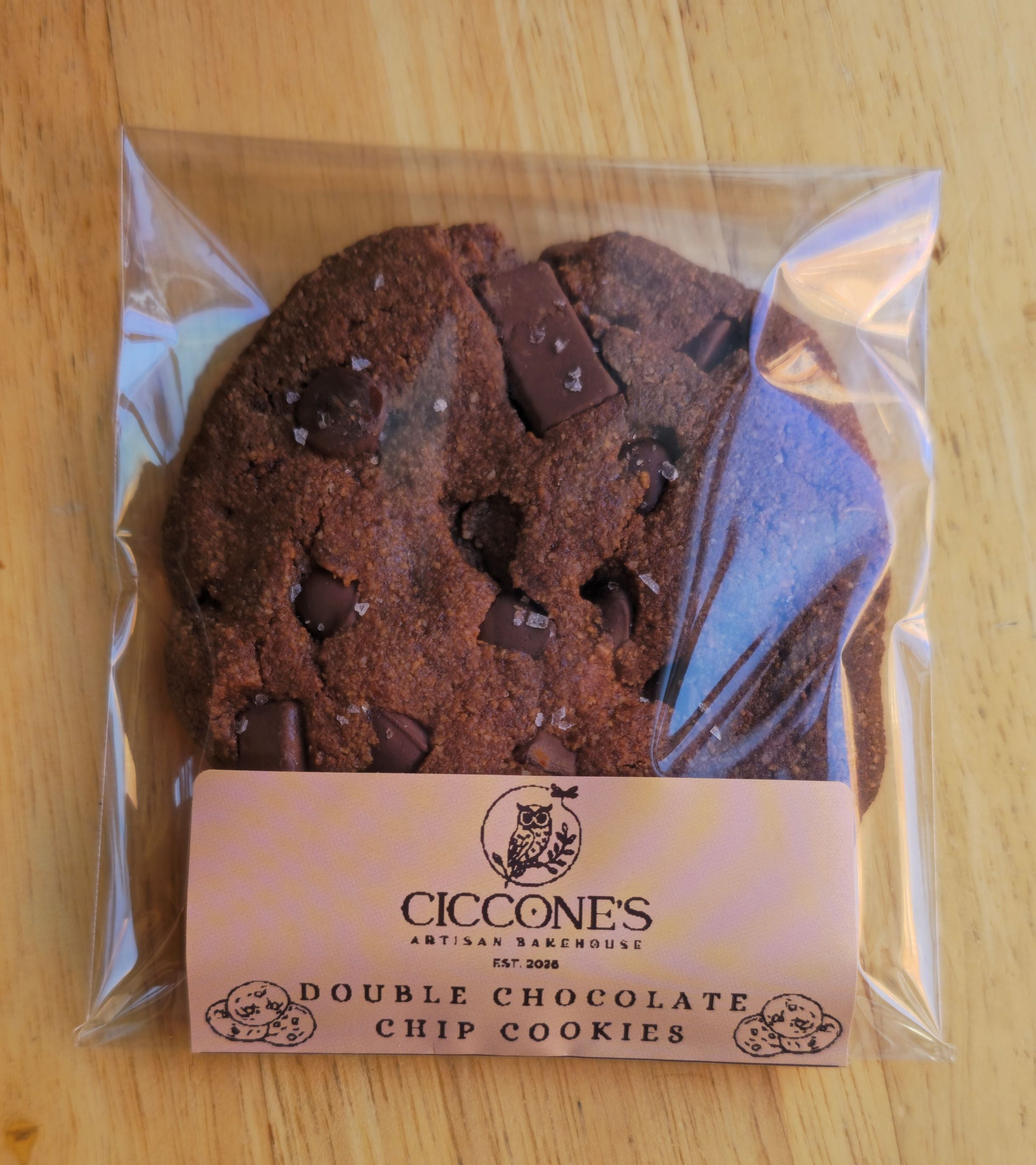 Packaged double chocolate chip cookies with Ciccone's branding on a wooden surface