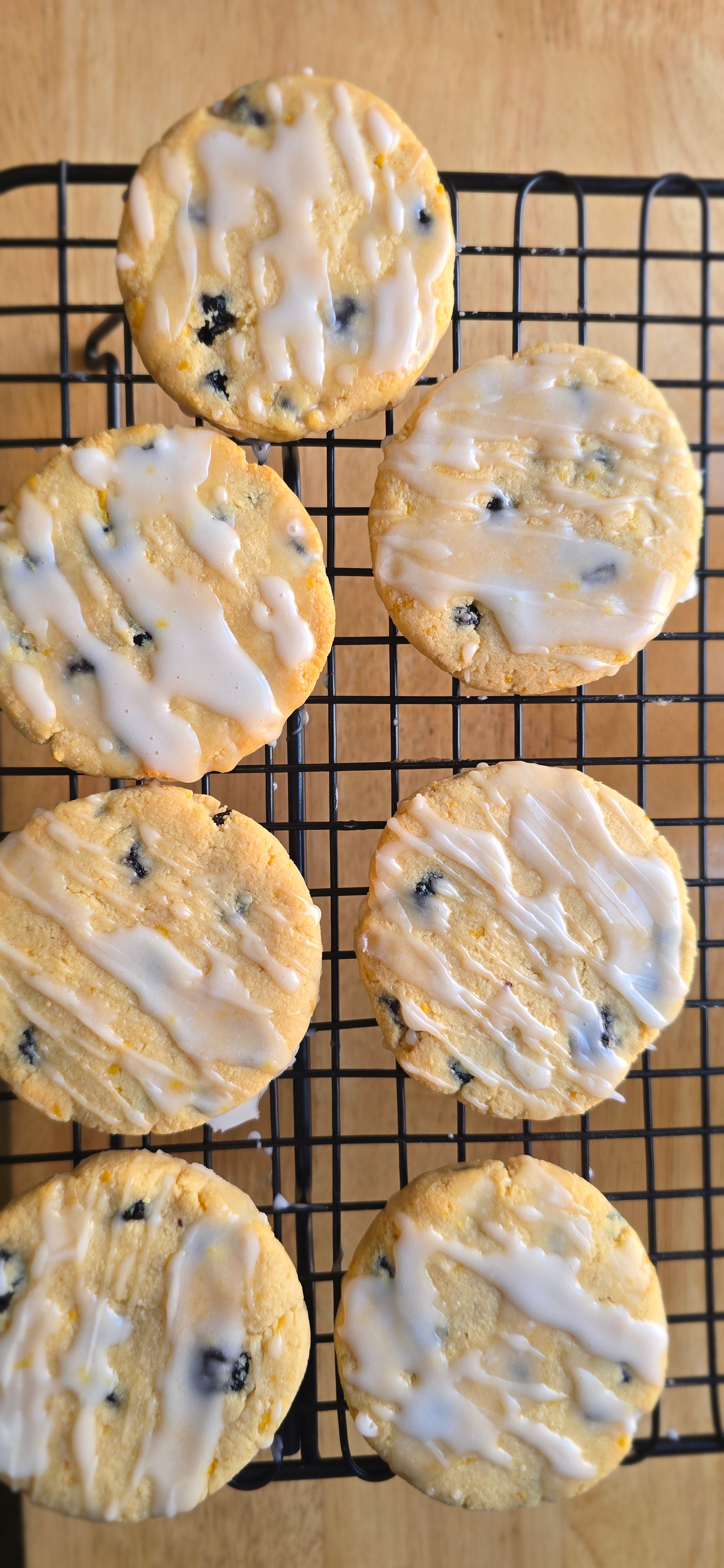 Blueberry cookies with white icing on a cooling rack
